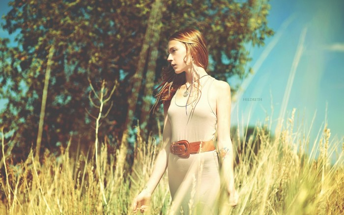 Woman in a field with trees and sky