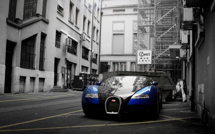 Blue Bugatti Veyron parked in alley with scaffolding