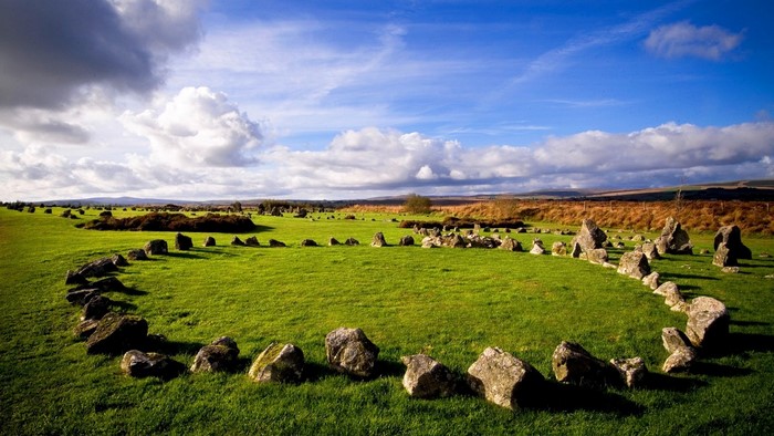 Stone circle in a grassy field under a cloudy sky
