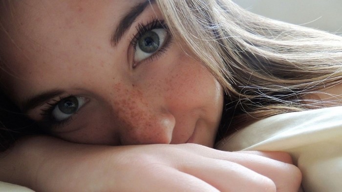 Close-up of a Young Woman with Green Eyes and Freckles