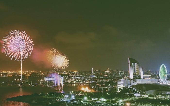 Cityscape at Night with Fireworks and Ferris Wheel