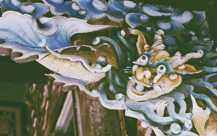 Close-up of a colorful dragon carving with blue and white waves