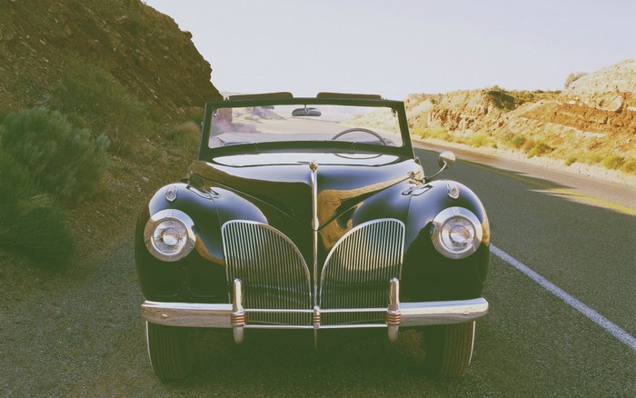 Vintage black convertible car on a desert road