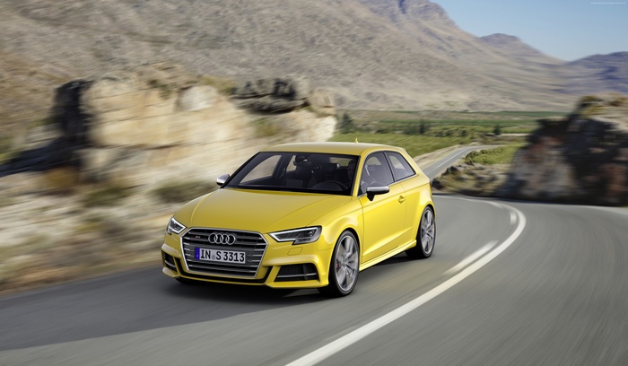 Yellow Audi S3 driving on a winding road