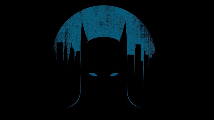 Batman silhouette against a blue moon and city skyline
