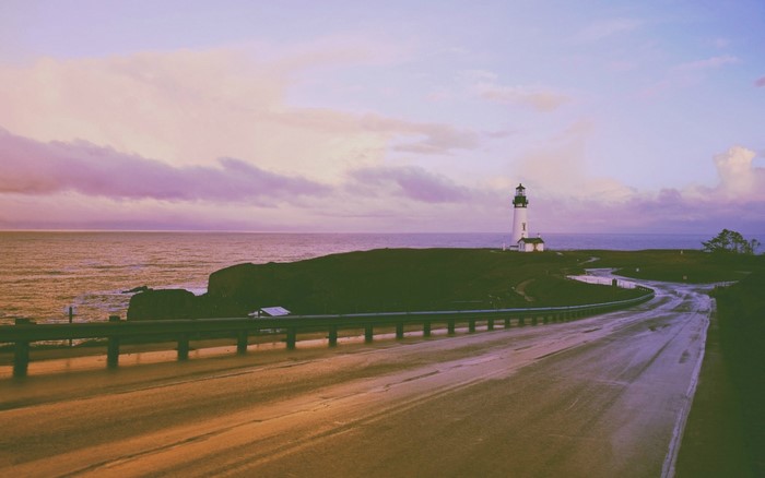 Lighthouse on a coastal hill overlooking the sea at sunset