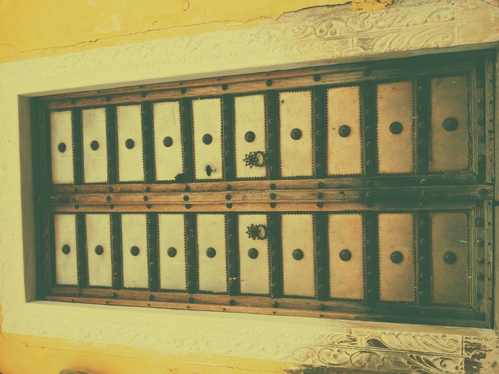 Ornate wooden window with metal panels and decorative trim