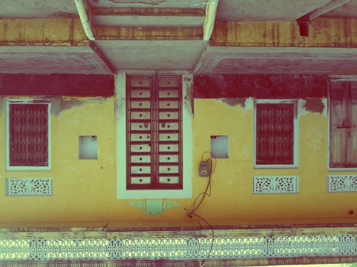 Yellow building facade with windows and doors in India