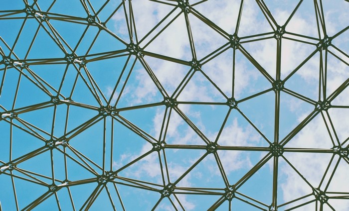 Geometric structure against a blue sky with clouds