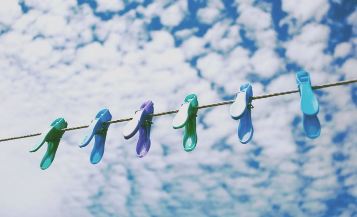 Colorful clothespins on a clothesline against a cloudy sky
