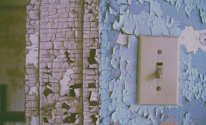 Peeling paint on wall with light switch