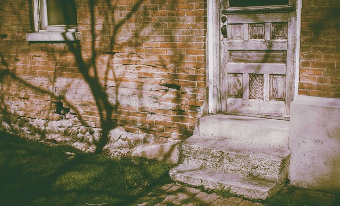Old brick house with a weathered door and window