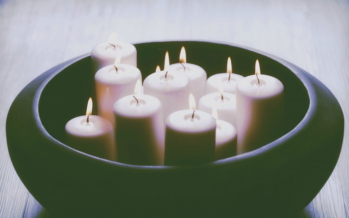 Burning candles in a dark bowl