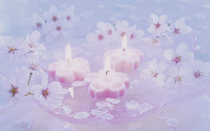 Pink cherry blossom candles and flowers in a dish