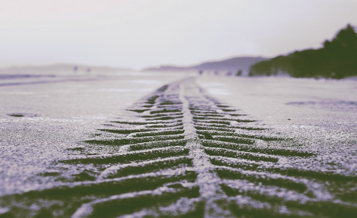Tire tracks in the snow on a beach