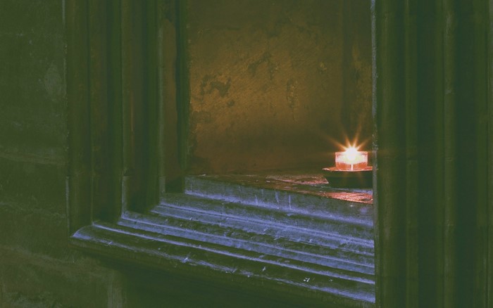 Candle burning in a stone alcove