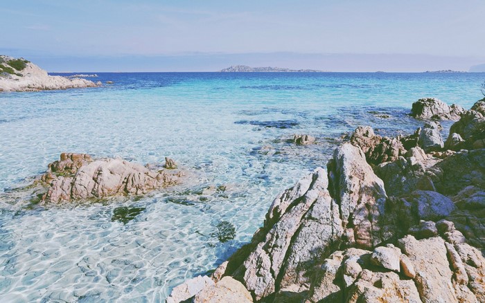 Rocky coastline with clear turquoise water and distant islands