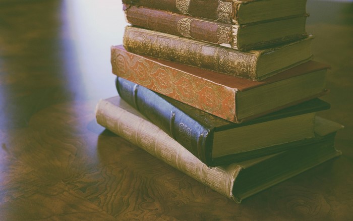 Stack of old vintage books on a wooden table