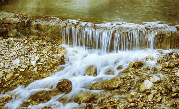 Small waterfall flowing over rocks in a stream