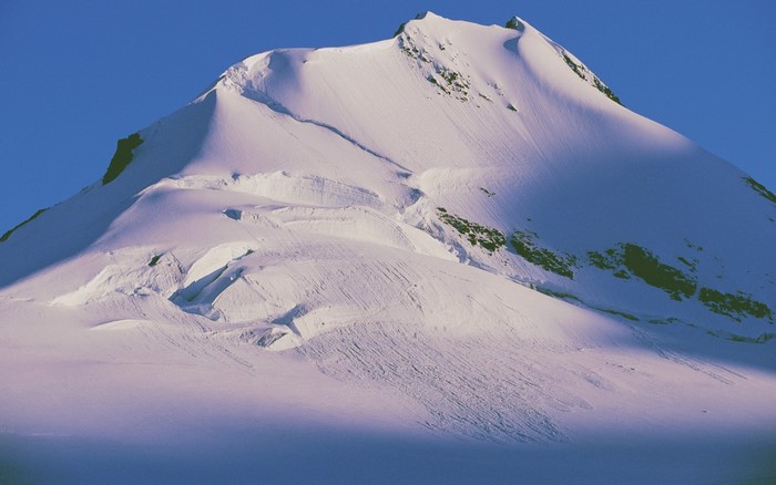 Snow-covered mountain peak under a clear blue sky