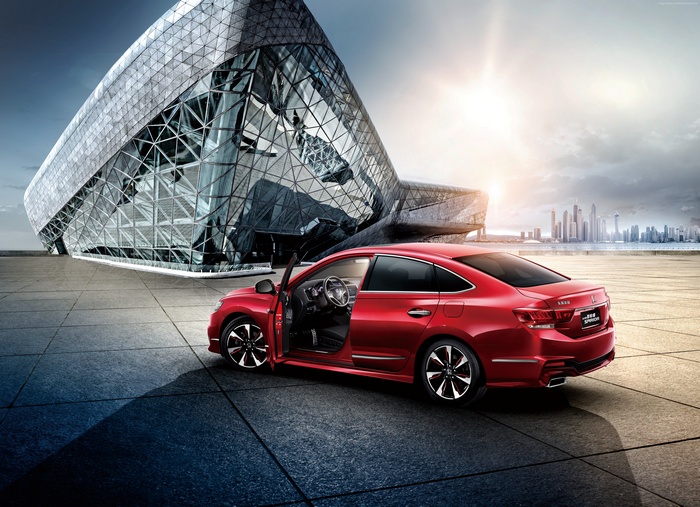 Red Honda Spirior Si sedan parked by modern building