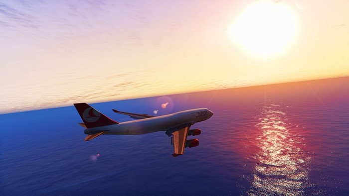 Turkish Airlines airplane flying over the ocean at sunset