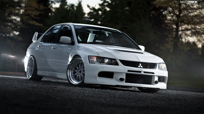 White Mitsubishi Lancer Evolution IX parked on gravel
