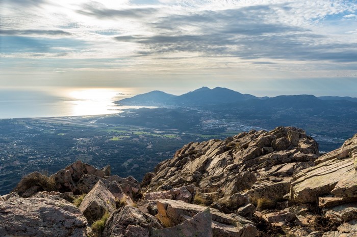Rocky mountain summit overlooking the sea and a coastal town