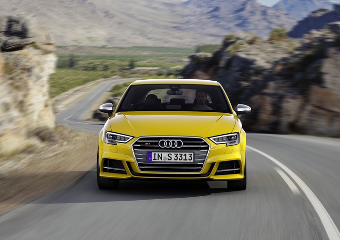 Yellow Audi S3 driving on a winding road