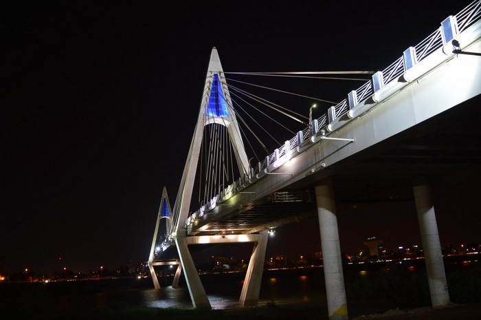 Modern cable-stayed bridge illuminated at night