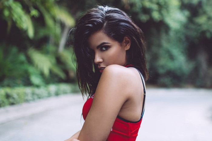 Woman in red top posing outdoors