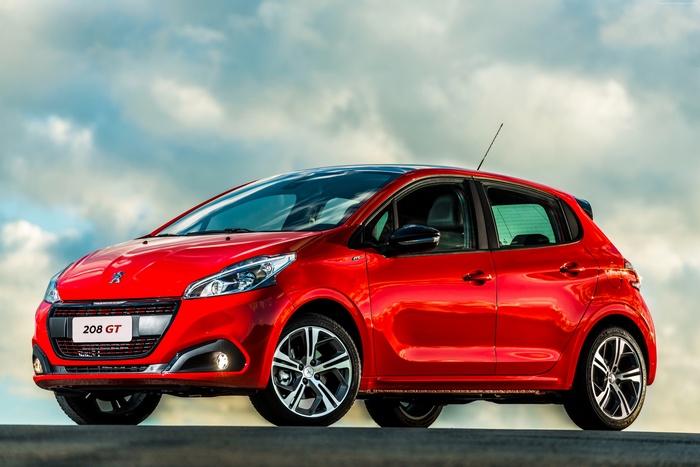 Red Peugeot 208 GT hatchback with clouds