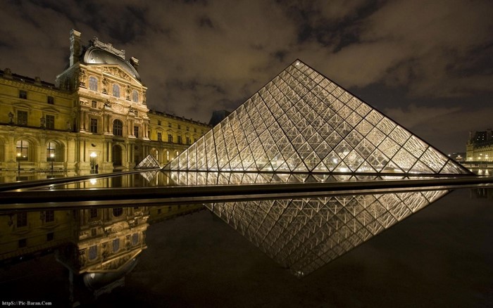Louvre Museum pyramid at night with reflection