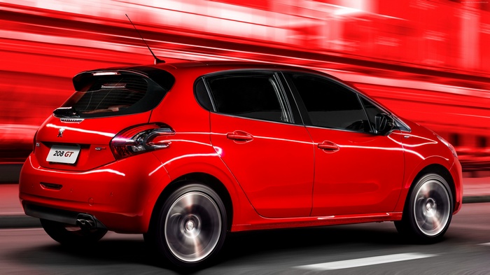 Red Peugeot 208 GT hatchback driving fast