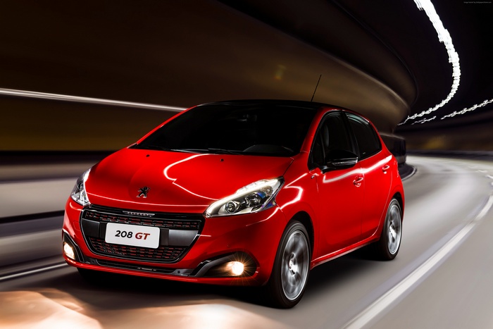 Red Peugeot 208 GT hatchback driving in a tunnel