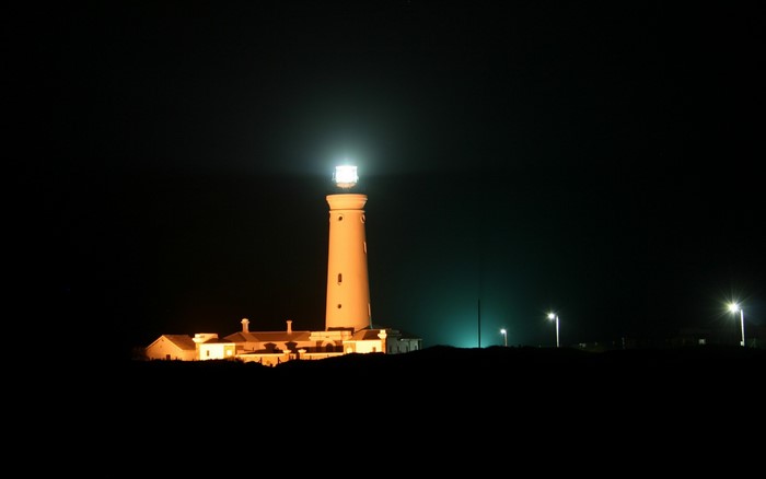 Lighthouse and buildings at night with street lights
