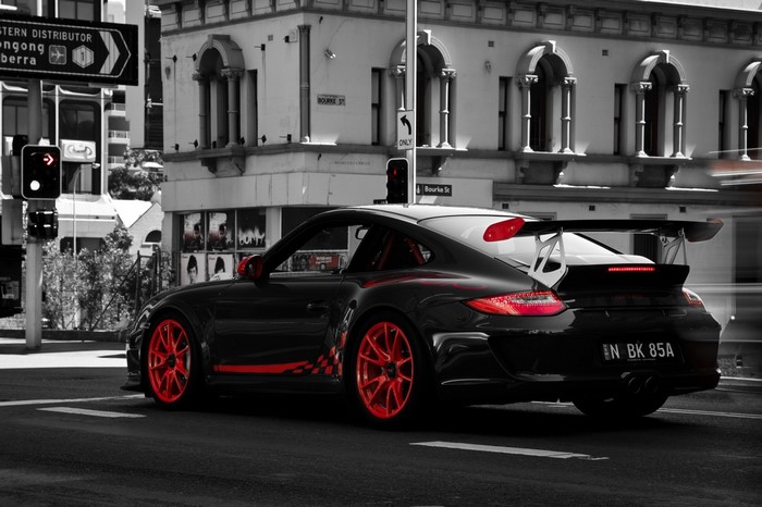 Black Porsche 911 GT3 RS with red accents on a city street