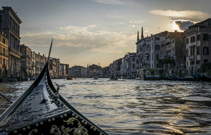 Venice canal with gondola at sunset