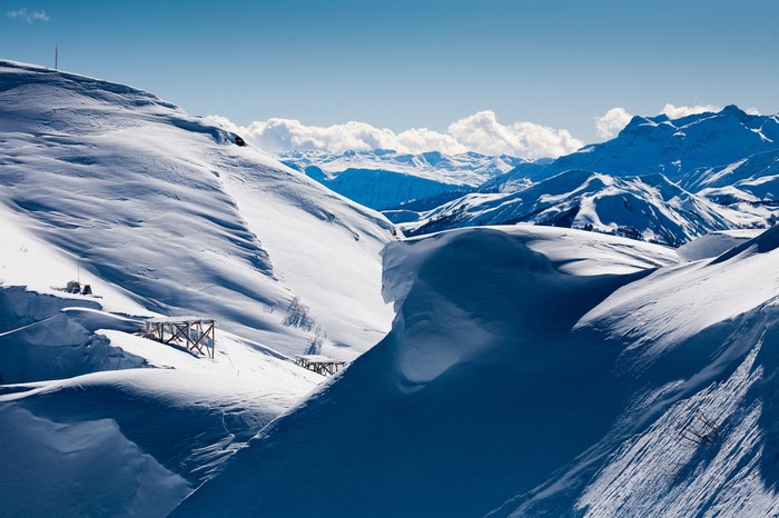Snowy mountain landscape with wooden structures