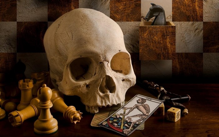 Still life with skull, chess pieces, tarot card, and dice