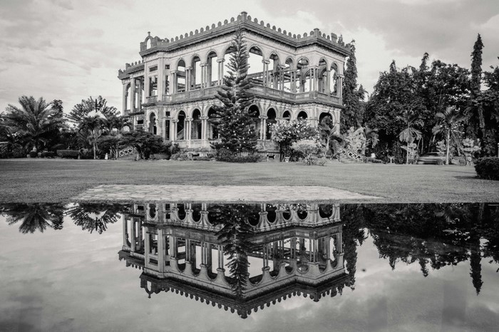 Ruined mansion with reflection in water, Philippines
