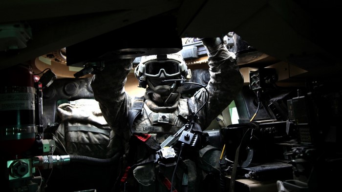 Soldier in a tank working on equipment