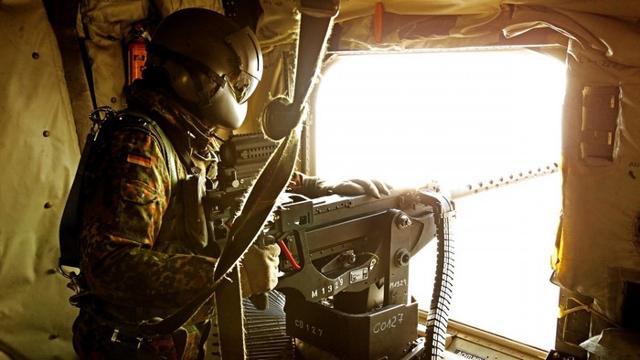 Soldier with machine gun in helicopter
