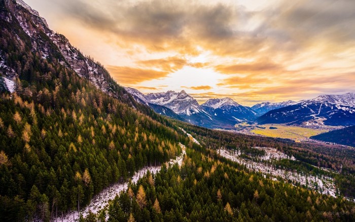 Mountain valley with forest and sunset sky
