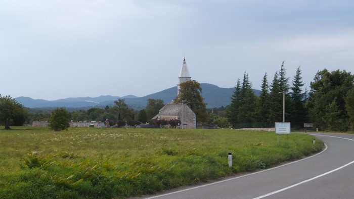 Church with a spire in a rural landscape in Slovenia