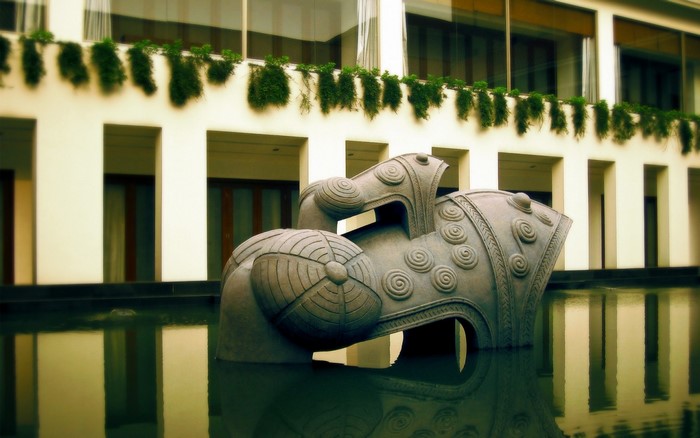 Stone sculpture in a water feature in front of a building