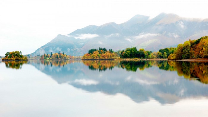 Autumn landscape with islands and mountains reflected in a lake