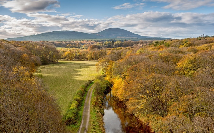 Autumn landscape with canal and distant hills