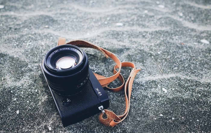Fujifilm X-E1 camera with lens on sand