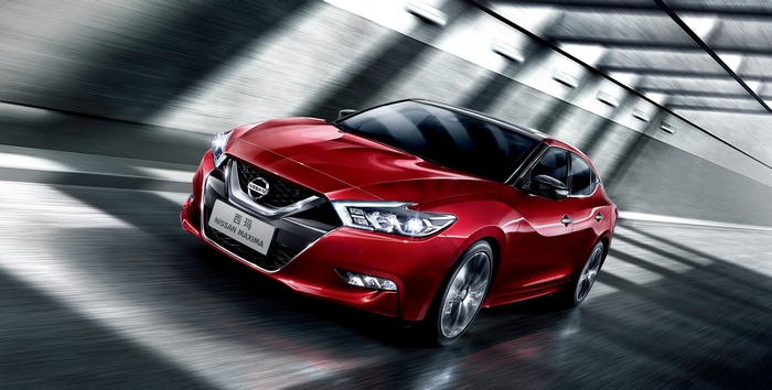 Red Nissan Maxima driving through a tunnel